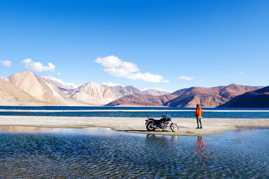 Witness the breathtaking views and scenery of the majestic Ladakh mountains as you ride a bike to the Pangong Lake.