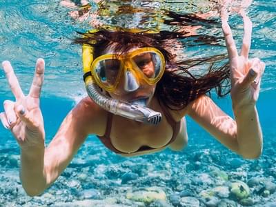 Snorkel in crystal clear water of Coral Island
