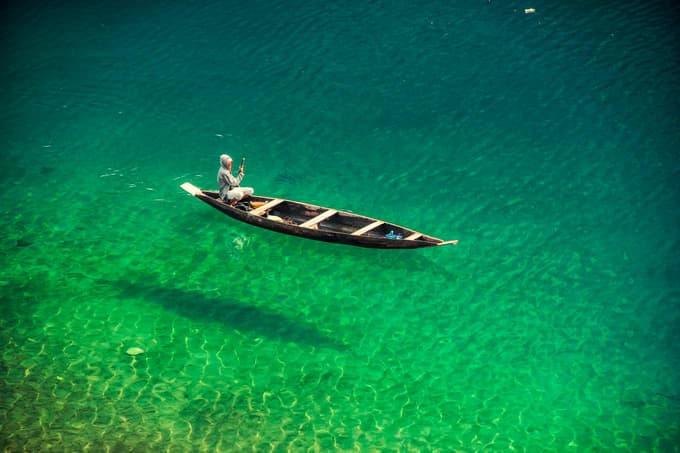 At Dawki, relax in the crystal clear waters while boating