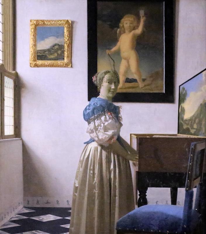 A Young Woman Standing At A Virginal By Johannes Vermeer