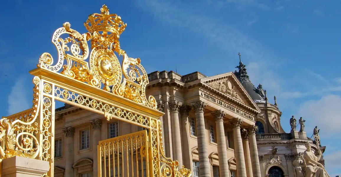 Take in the glorious entry gates of the Palace of Versailles