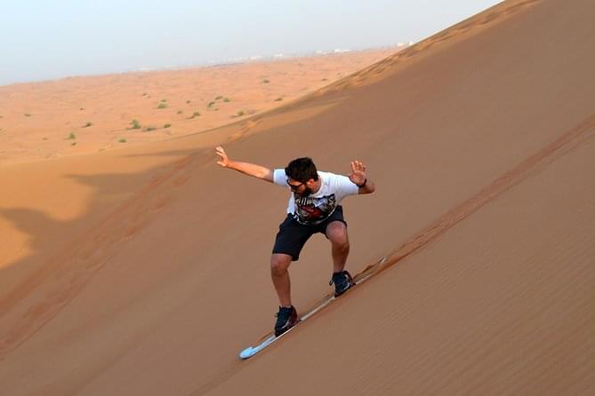Experience the thrill of sandboarding on the mesmerizing red dunes