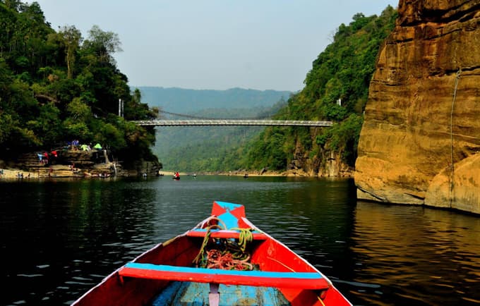 Drift through Dawki’s emerald waters surrounded by lush hills