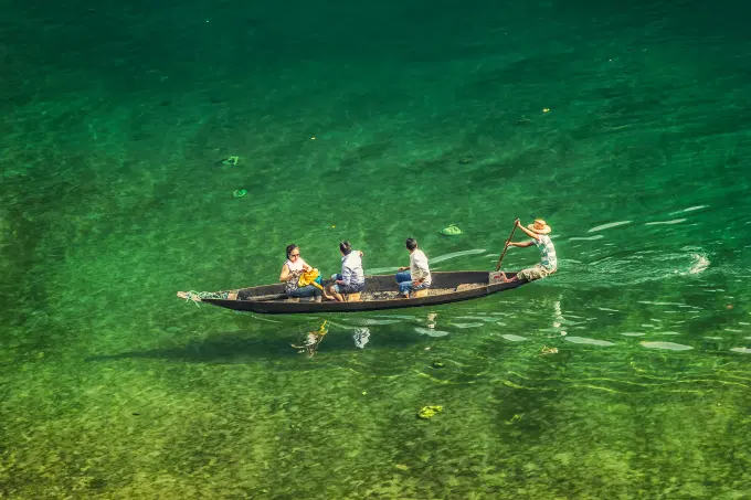 Catch mirror-calm lake views with pine hills all around at Umngot Falls