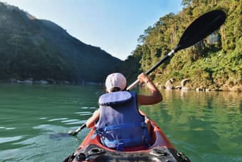Paddle through paradise surrounded by green hills and cliffs