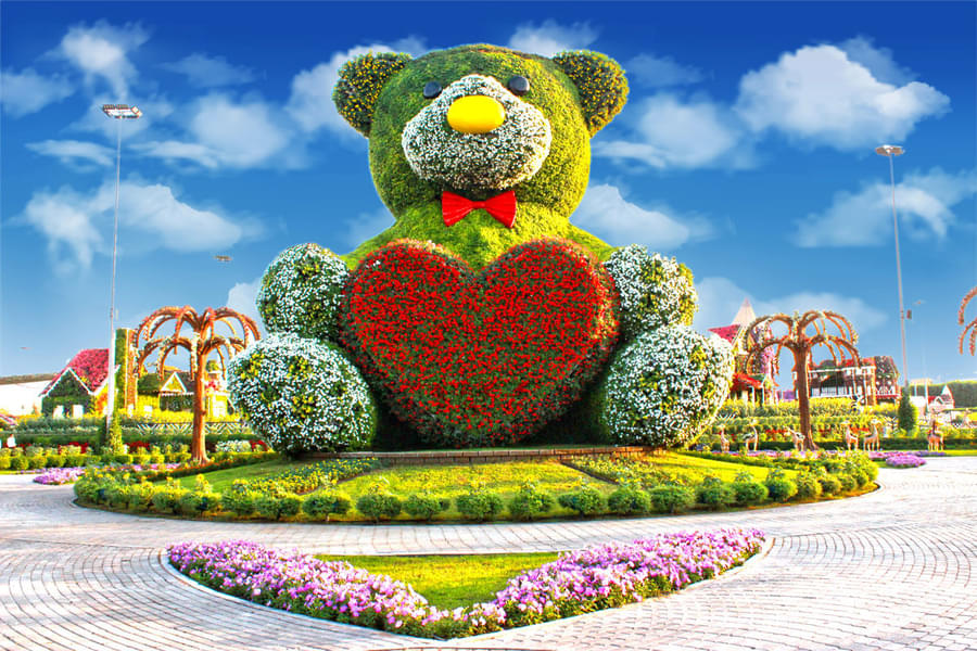 See a 40 feet high teddy bear covered with colorful flowers
