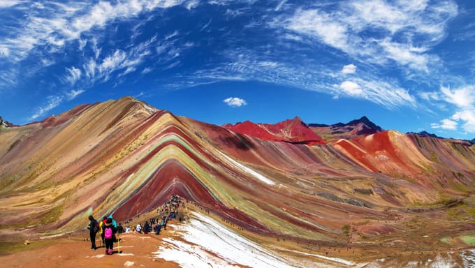 Hikers walking along trail toward Rainbow Mountain summit