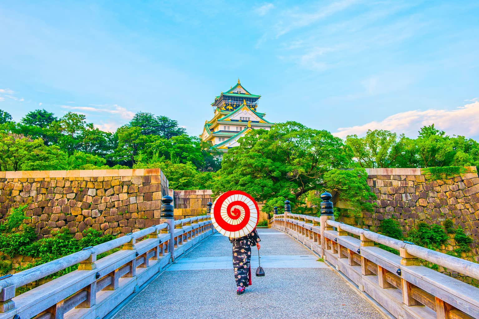 Osaka Castle with a traveler in a kimono holding a parasol.
