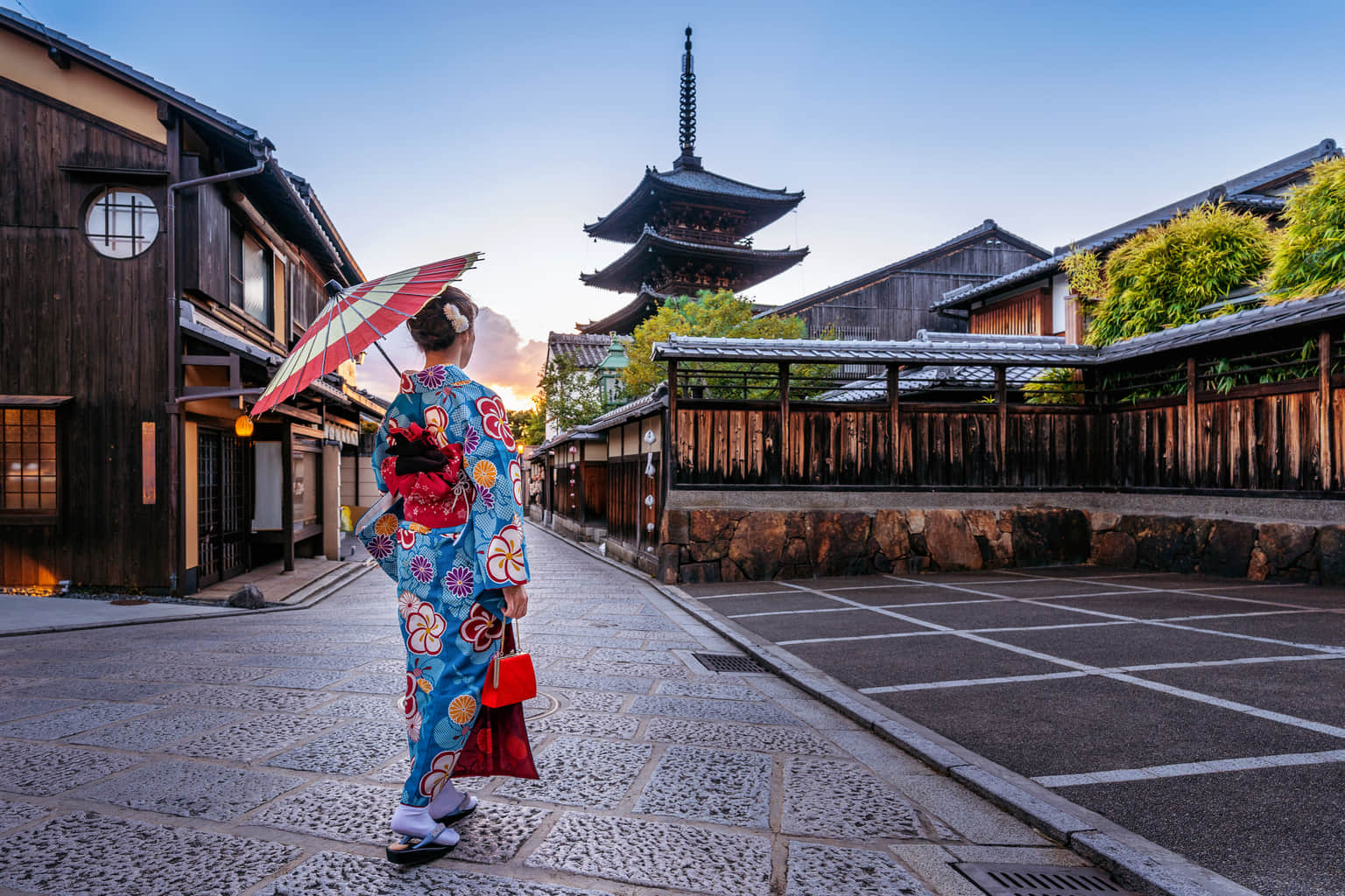 Kimono-clad woman strolling through historic Kyoto.