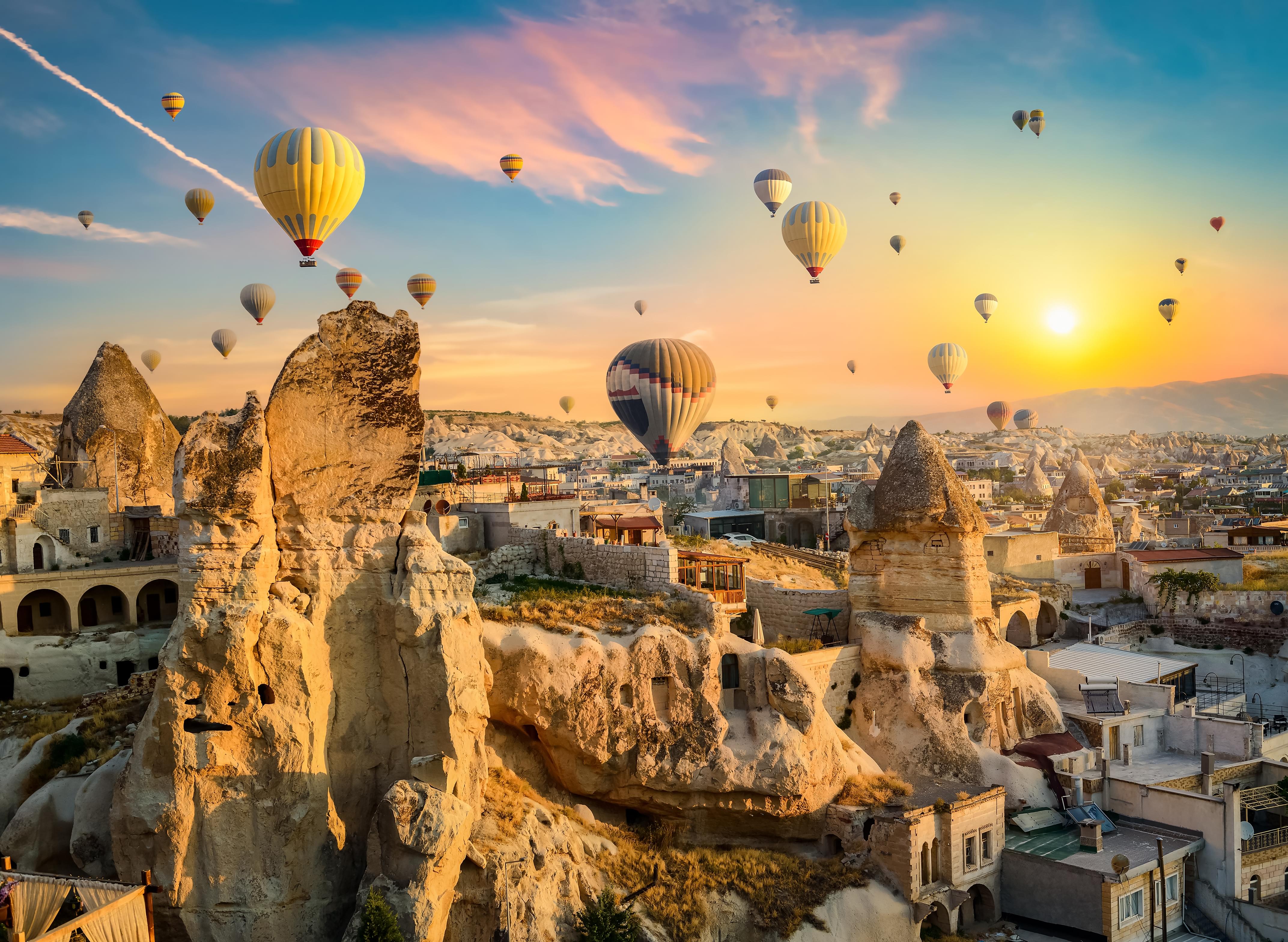 Hot Air Balloons Floating Above Cappadocia's Surreal Landscape At Sunrise