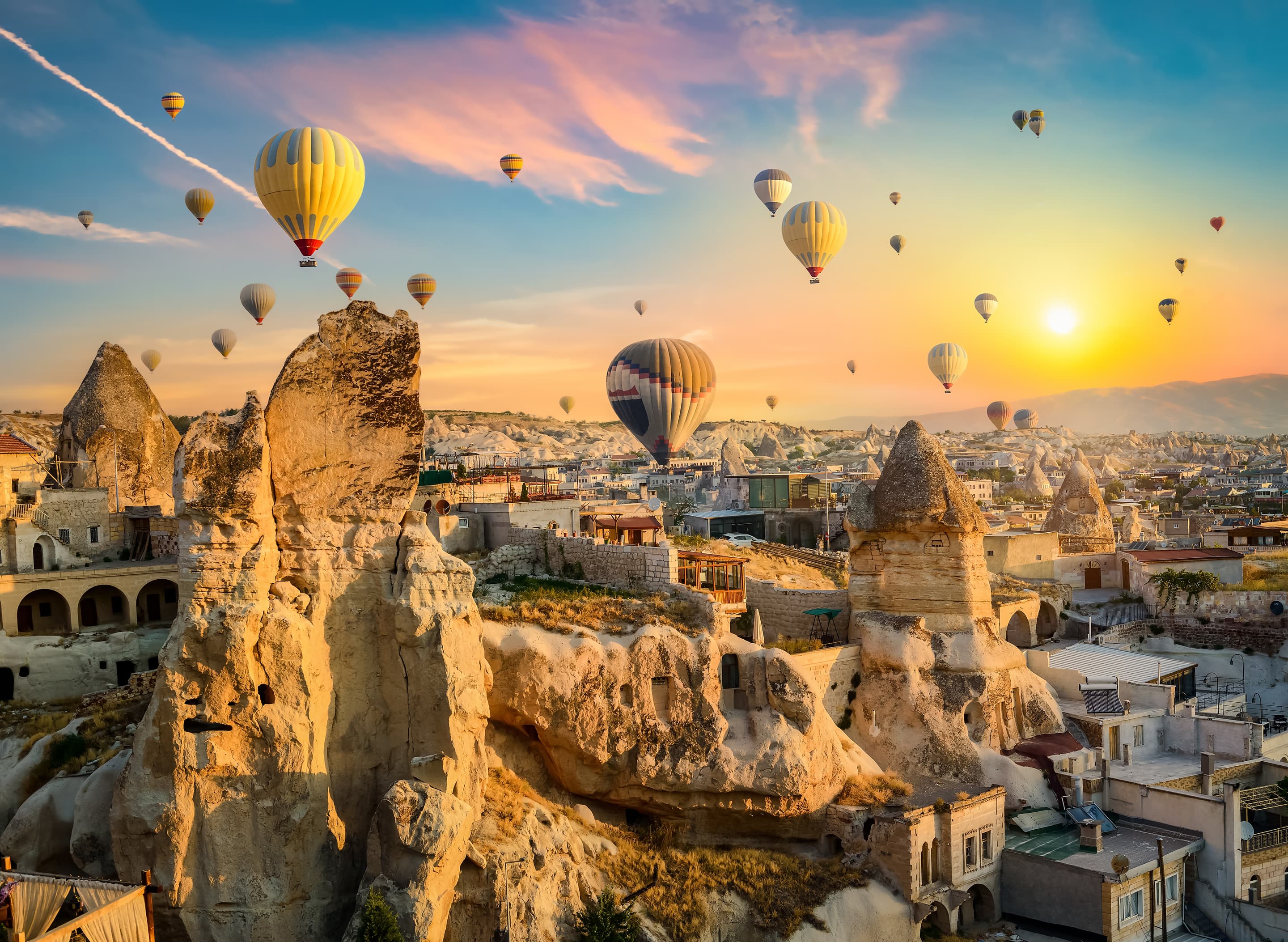 Hot Air Balloons Floating Above Cappadocia's Surreal Landscape At Sunrise
