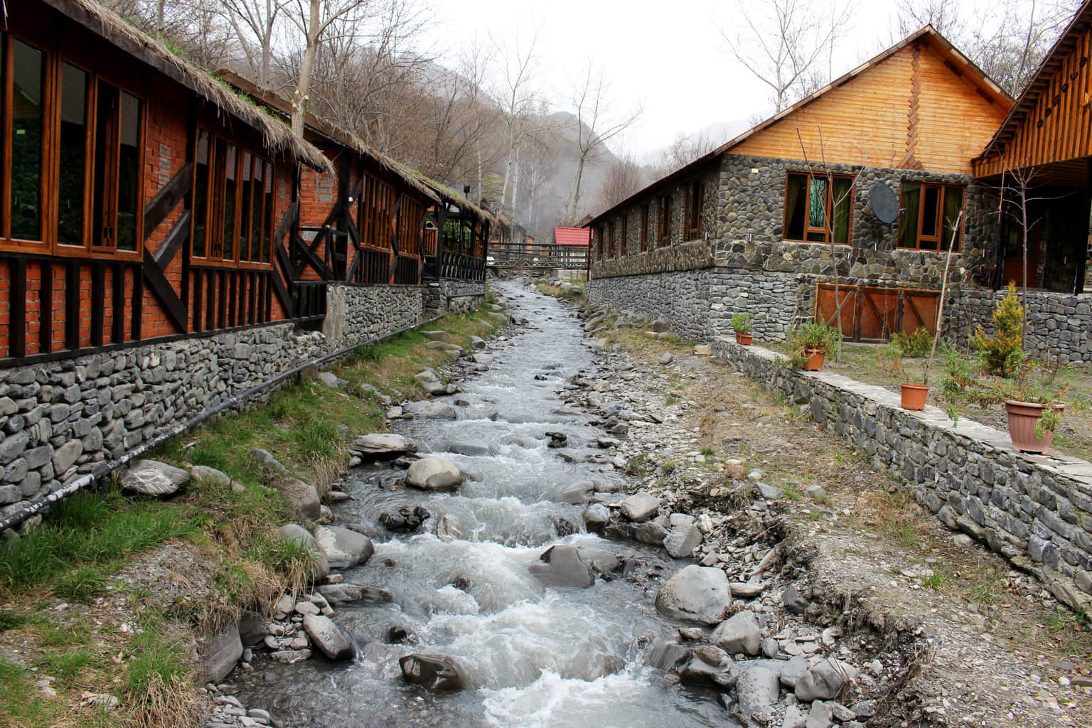 Rustic cottages lining a rocky stream in Azerbaijan.