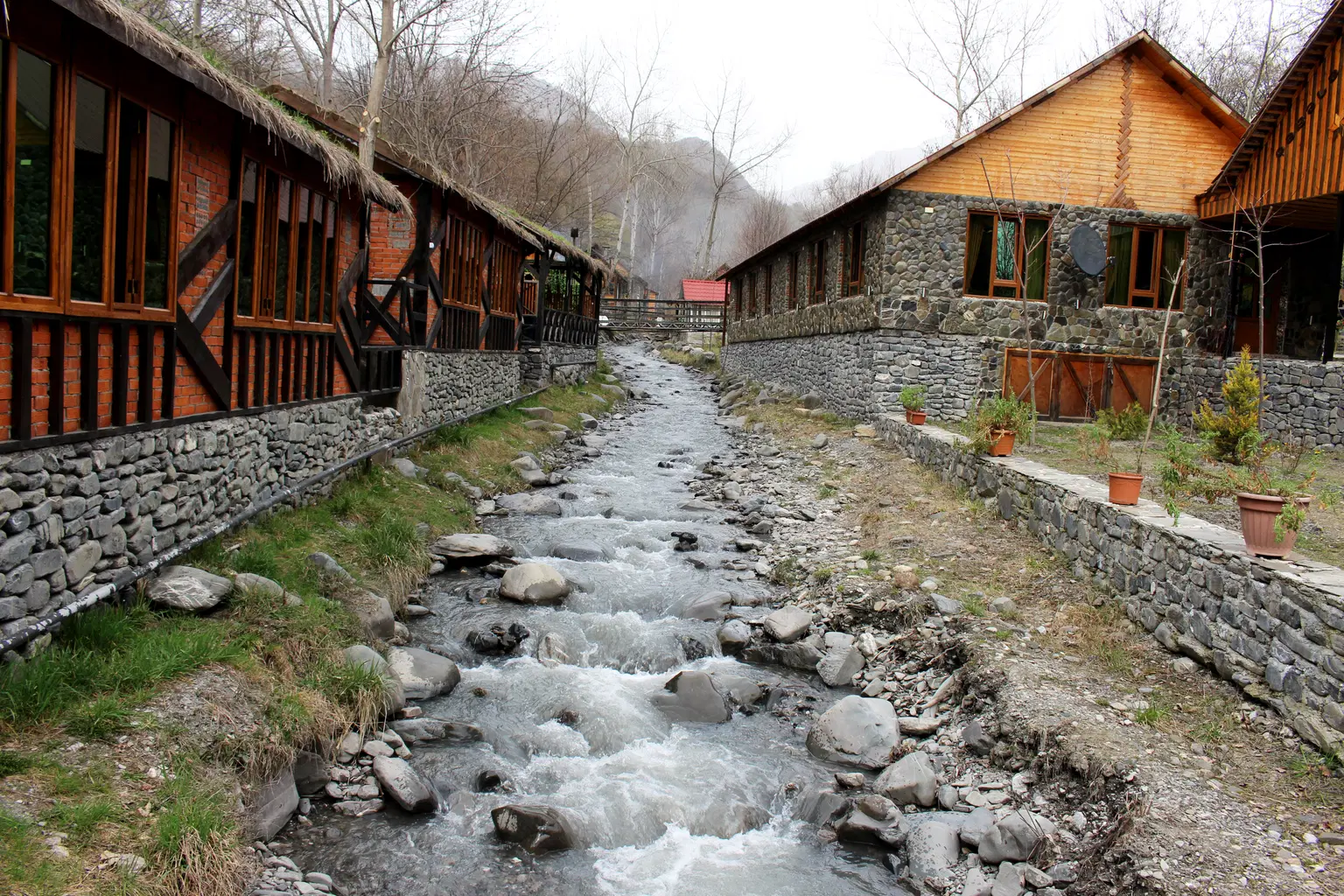Rustic cottages lining a rocky stream in Azerbaijan.