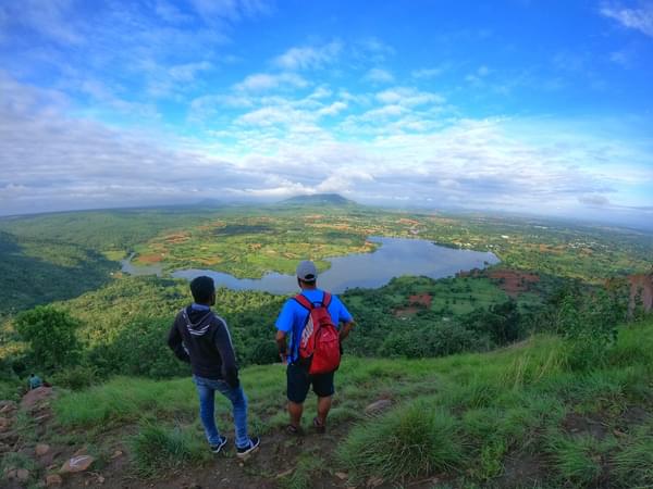 Trek through scenic trails lined with dense vegetation, granite boulders, and glimpses of the picturesque Thippagondanahalli Reservoir