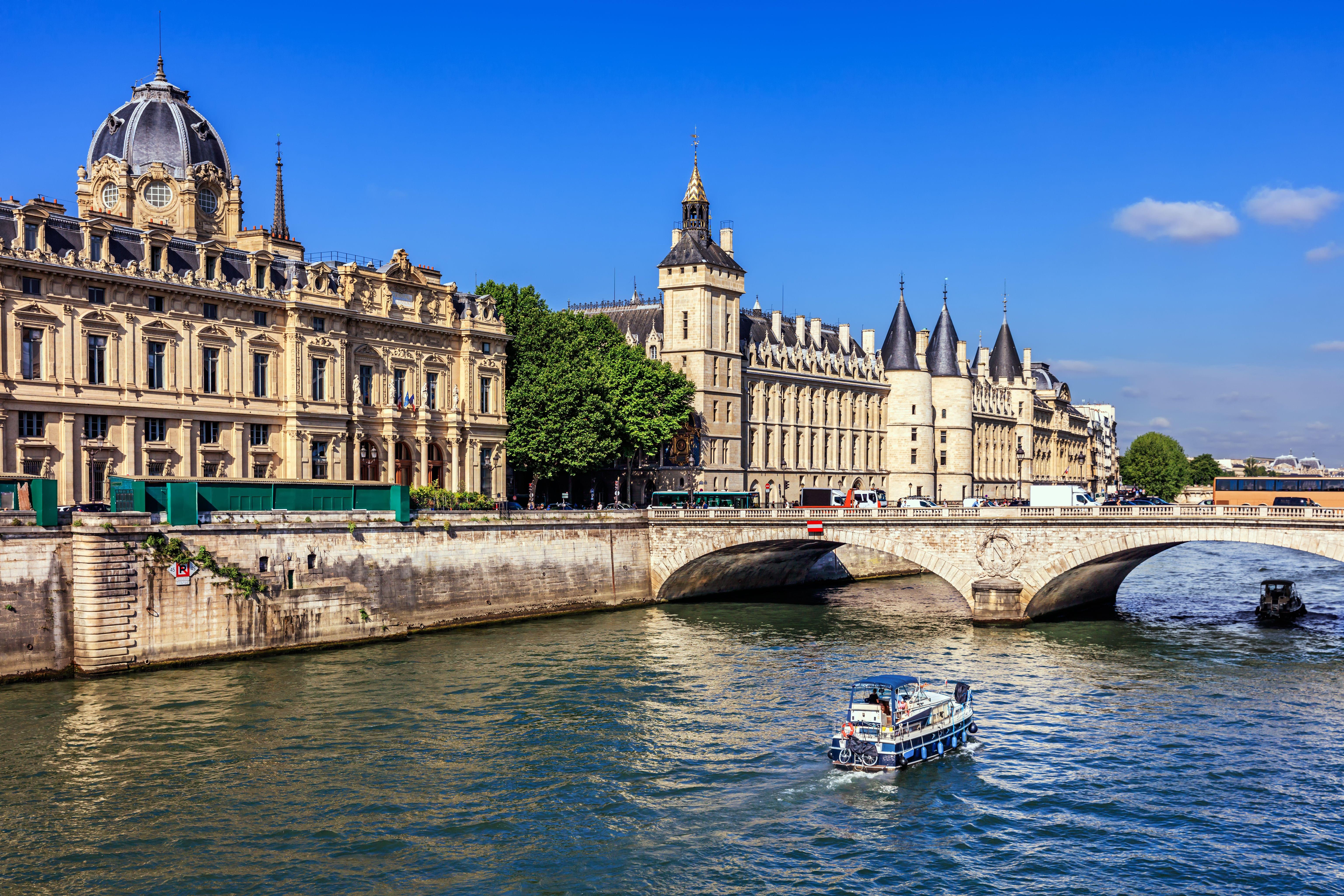 Conciergerie Castle and Seine River with cruise tour boat
