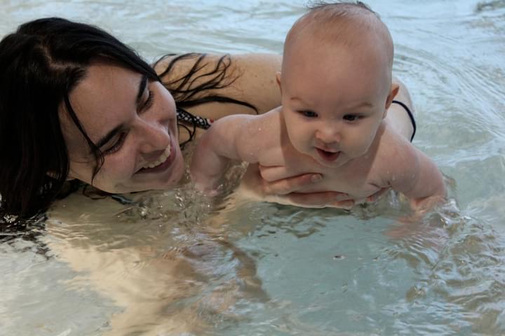 Infant swimming with the trainer