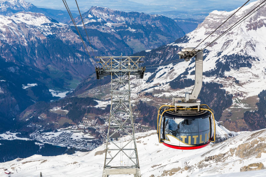 Enjoy a cable car ride gliding over the stunning mountain landscape of Titlis