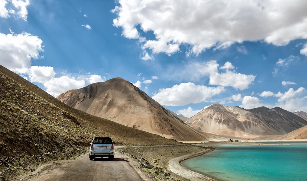 Drive through the scenic pathways of Pangong Tso on one side and the barren hills on the other