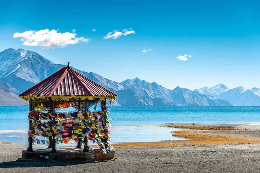 Immerse in the serenity of Pangong Tso's vast expanse of azure waters and rugged terrain