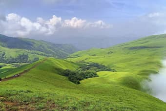 Marvel at stunning views of lush valleys and serene landscapes from Netravathi Peak