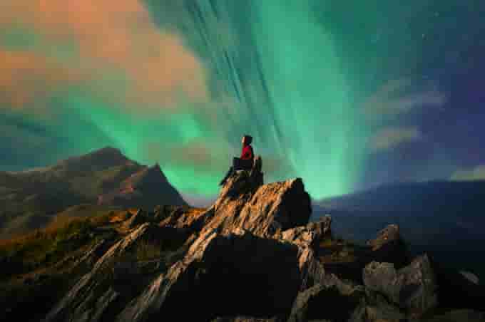 Girl enjoying the view of Northern Lights, Iceland