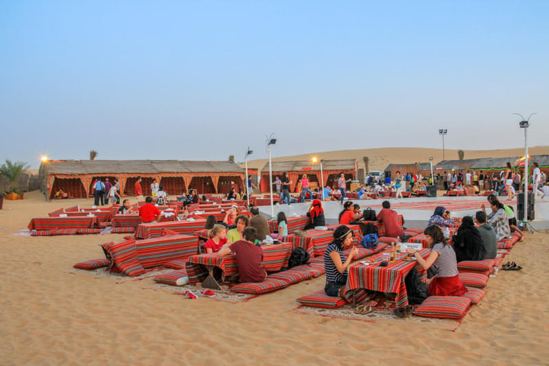 Tourists enjoying a Dubai desert safari adventure with Thrillophilia