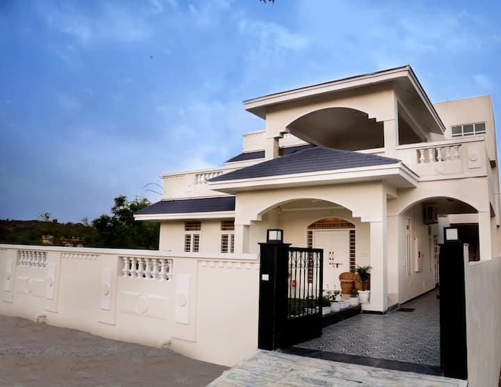 A White House Bungalow Amidst The Aravali Hills In Udaipur Image