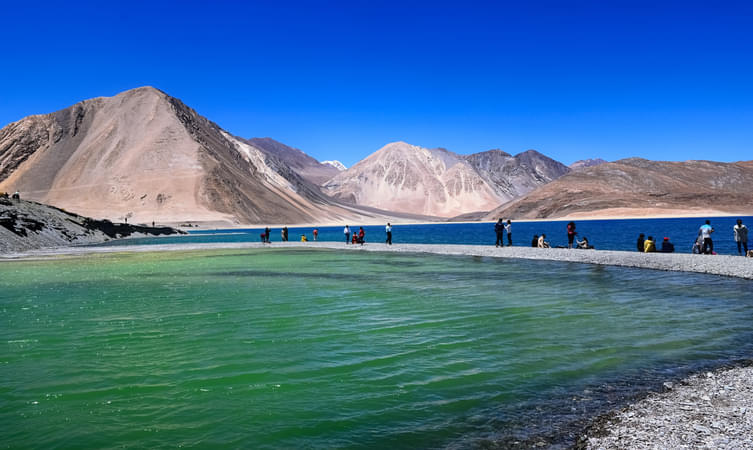Take in the serene views of the clear blue waters of Pangong Lake
