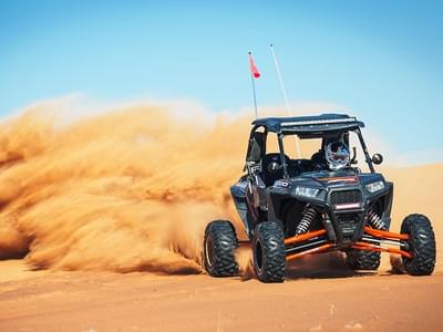 Create a sand storm behind as the buggy races through the landscape of Mleiha