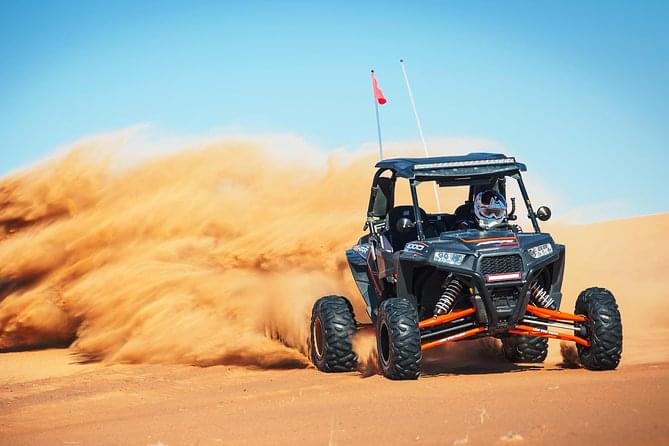 Create a sand storm behind as the buggy races through the landscape of Mleiha