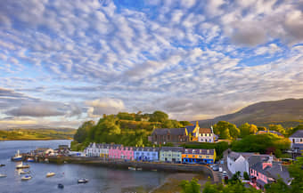 Immerse yourself in the charm of Portree, a harbor town framed by colorful houses and rugged cliffs