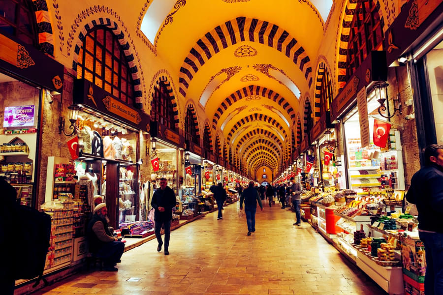 See the bustle of the well lit Grand bazaar