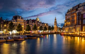 Glide through Amsterdam’s canals, admiring colourful houses and historic bridges